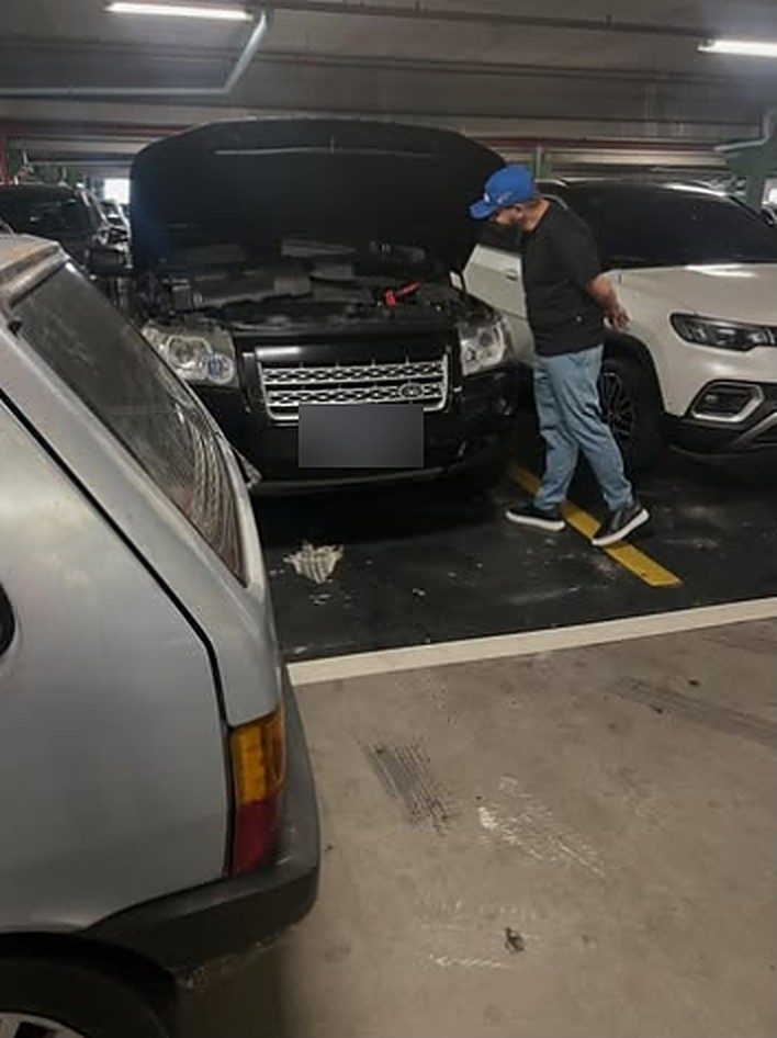 Príncipe do Socorro, socorro e mecânica móvel em Campinas: técnico de boné azul trabalhando em uma Land Rover com o capô aberto, em um estacionamento coberto